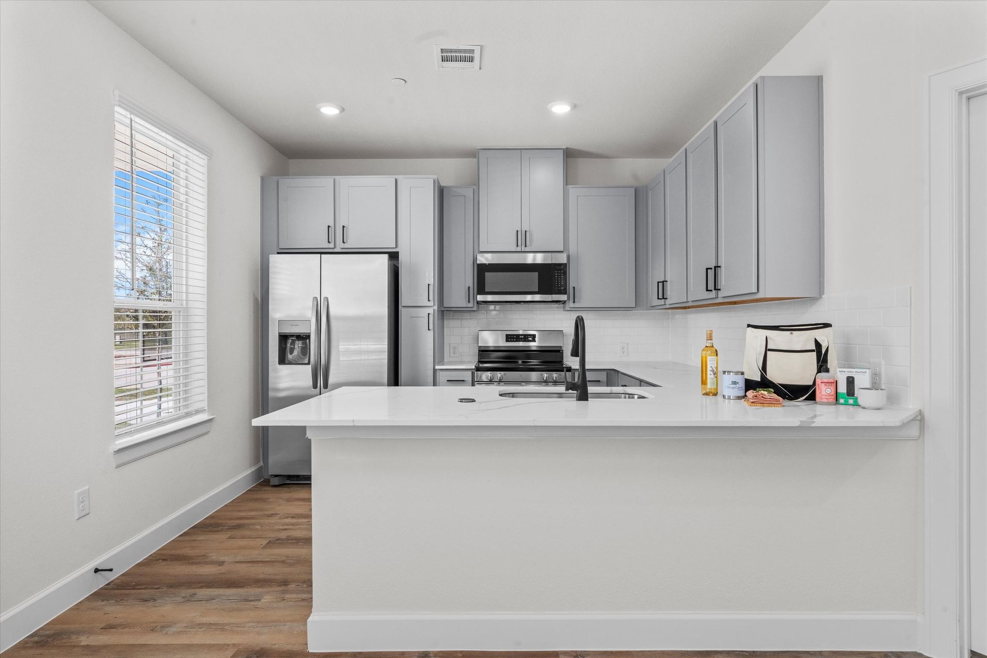 Open apartment kitchen with island, stainless steel appliances and modern cabinetry at Cottage Green Simpsonville