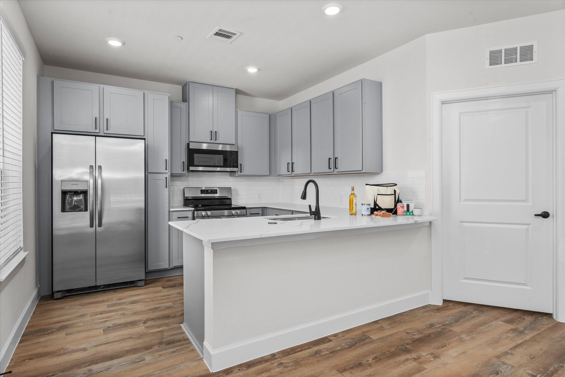 Spacious apartment kitchen with breakfast bar, quartz countertops and stainless steel appliances at Cottage Green Simpsonville