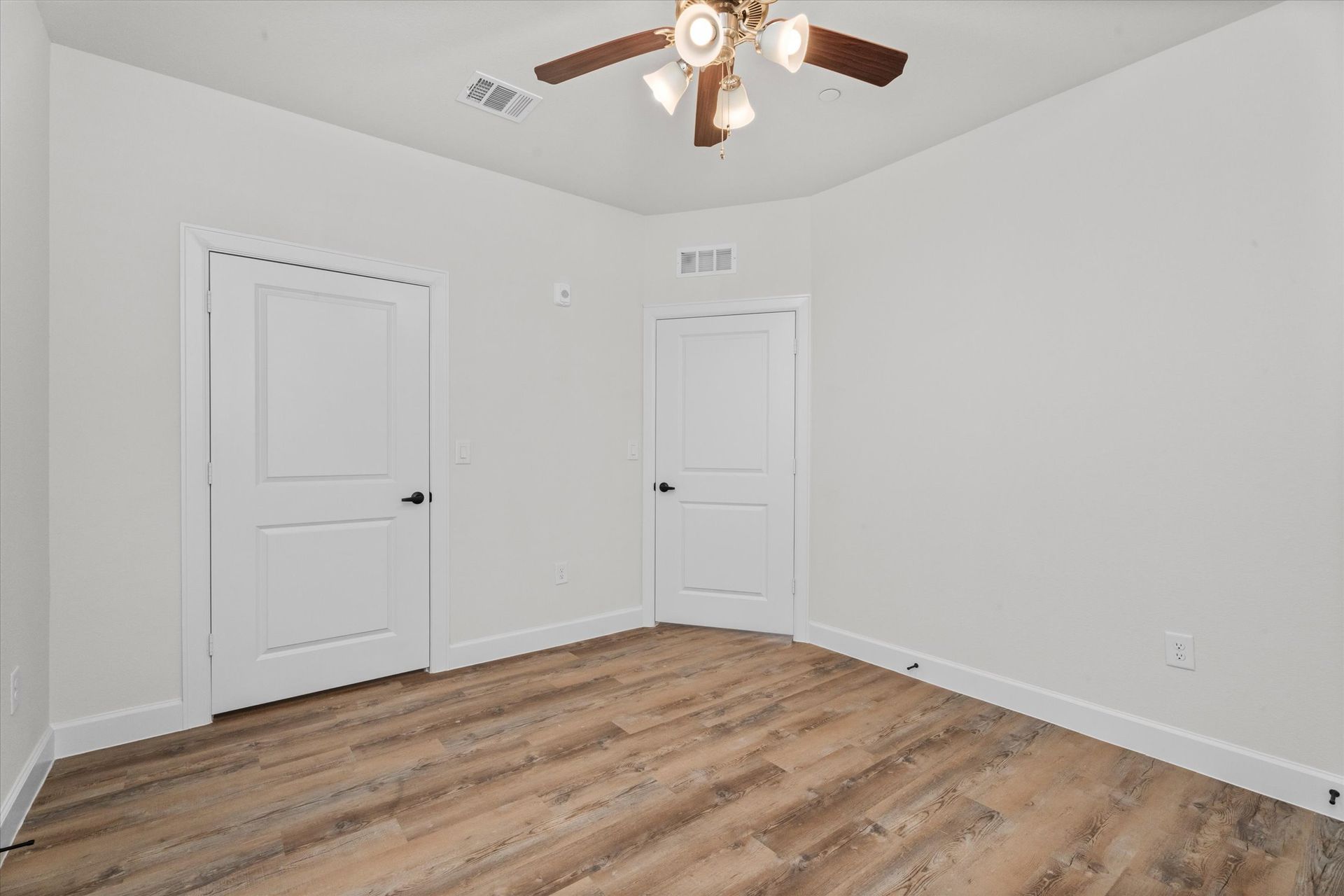 Unfurnished apartment bedroom with wood-style flooring at Cottage Green Simpsonville