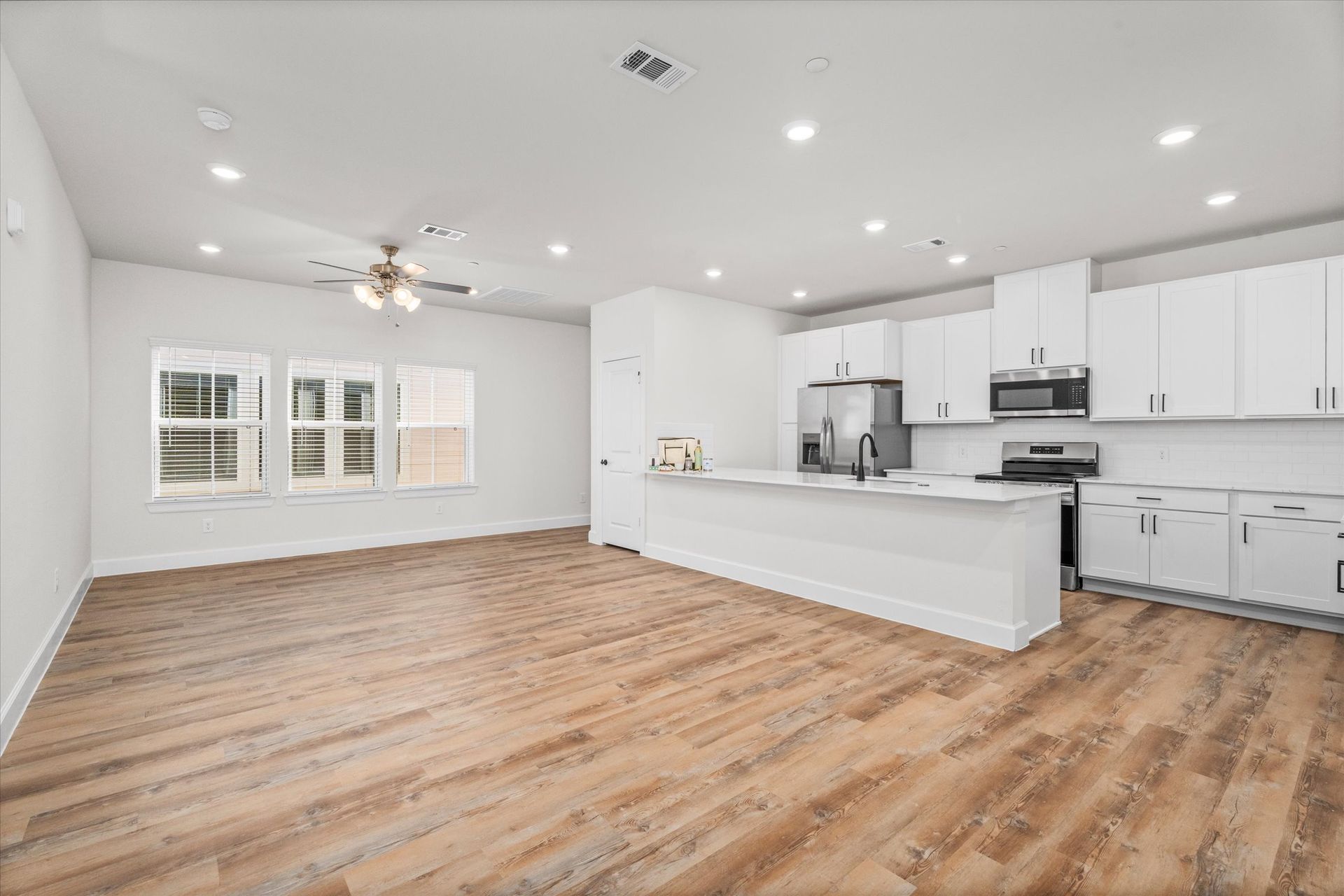 Open-concept apartment kitchen and living area at Cottage Green Simpsonville in Simpsonville, SC