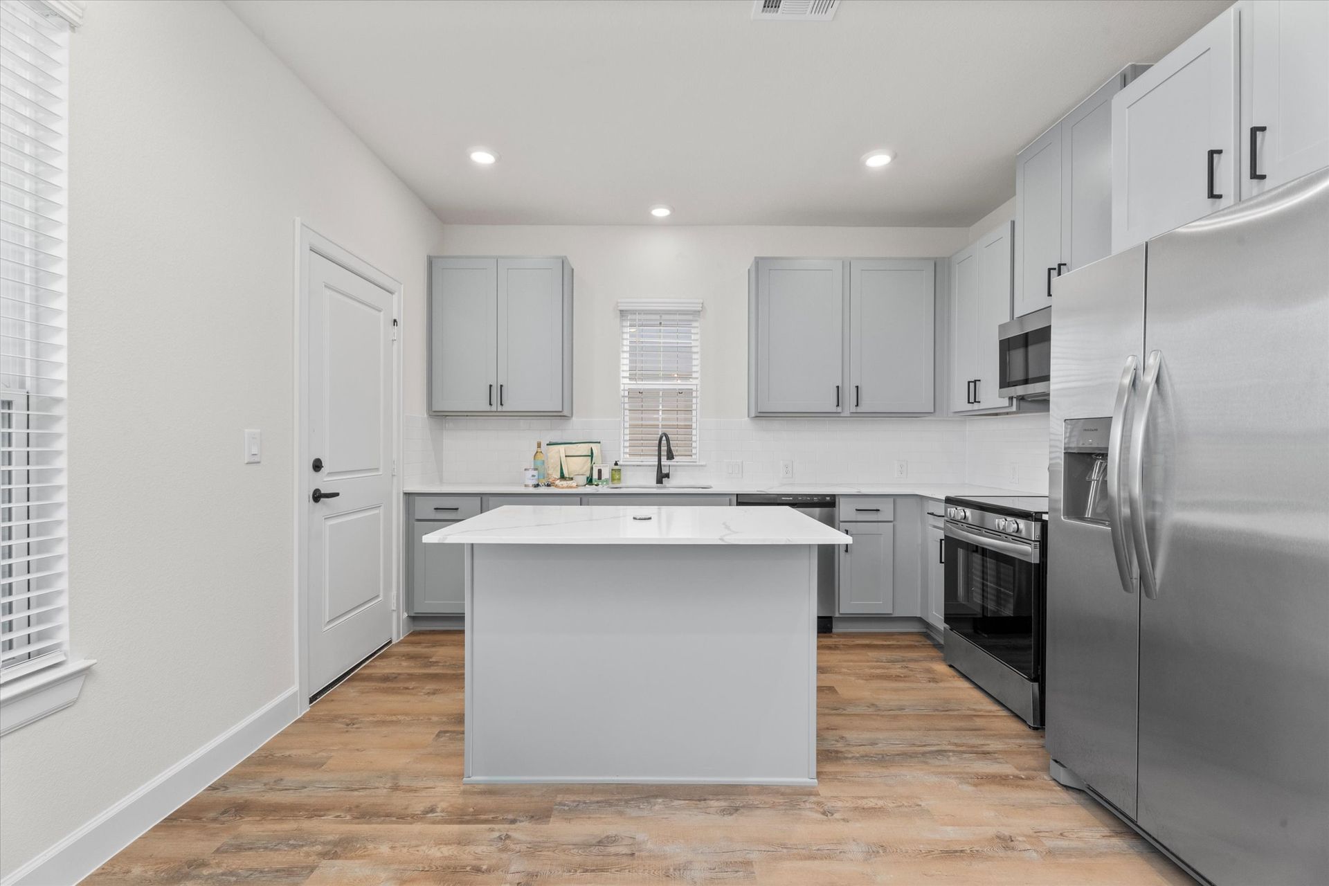 Modern apartment kitchen with center island and stainless steel appliances at Cottage Green Simpsonville