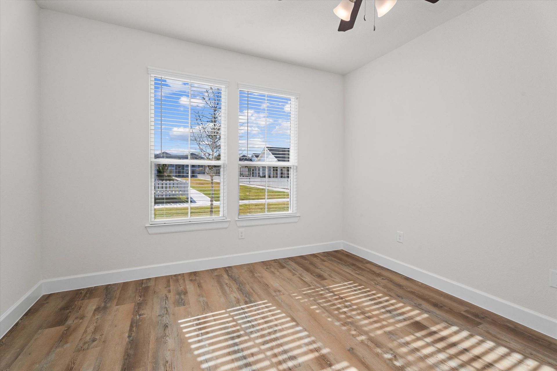 Bright apartment bedroom with large windows and wood-style flooring at Cottage Green Simpsonville