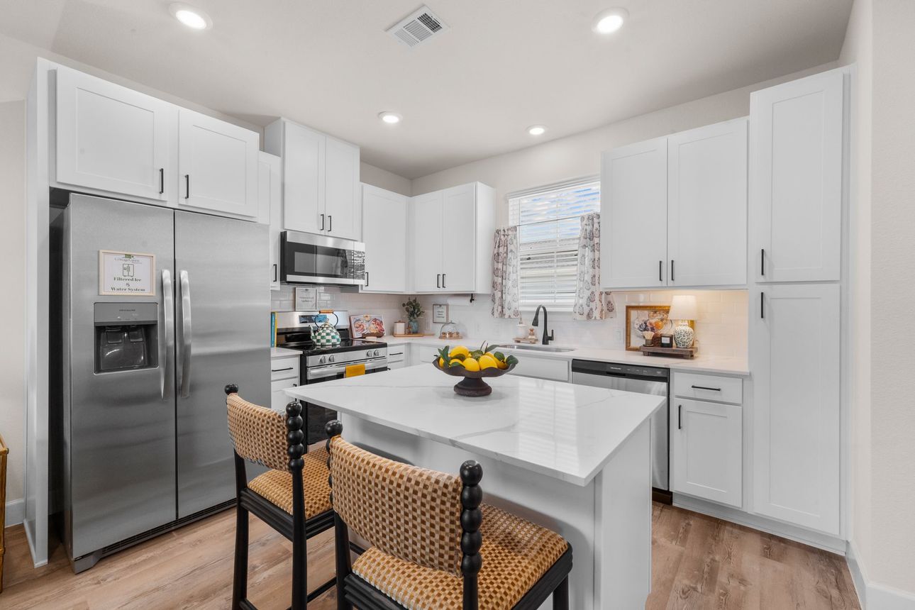 Modern kitchen at The Cottage Green Simpsonville apartments featuring stainless steel appliances and contemporary finishes.