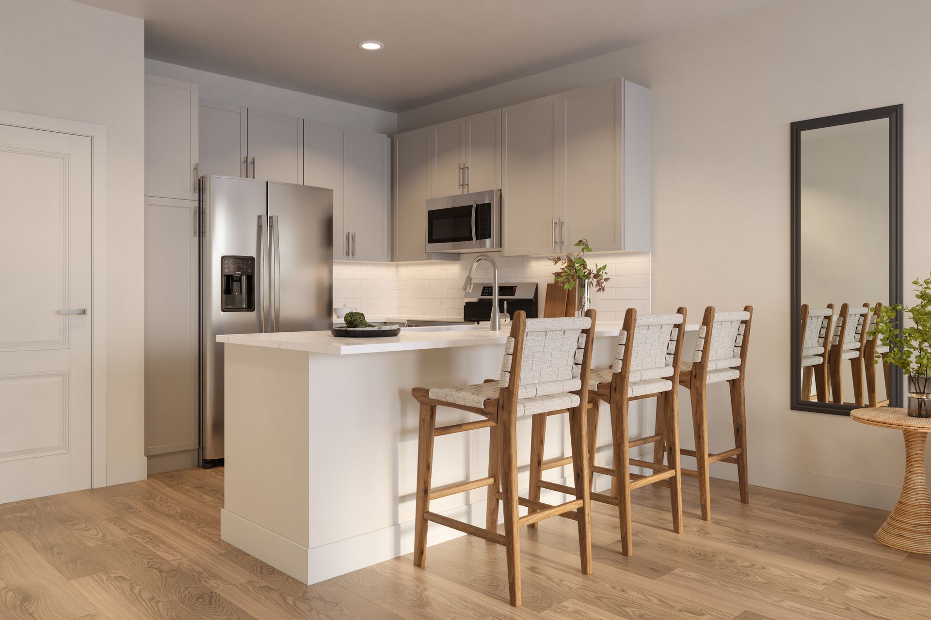 Modern kitchen with white island, bar stools, stainless appliances, and a wall mirror in a bright home interior