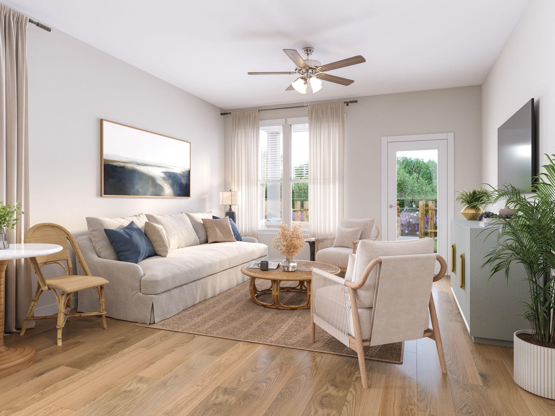 Bright living room with beige sofa, armchair, wood floors, ceiling fan, and large windows with curtains
