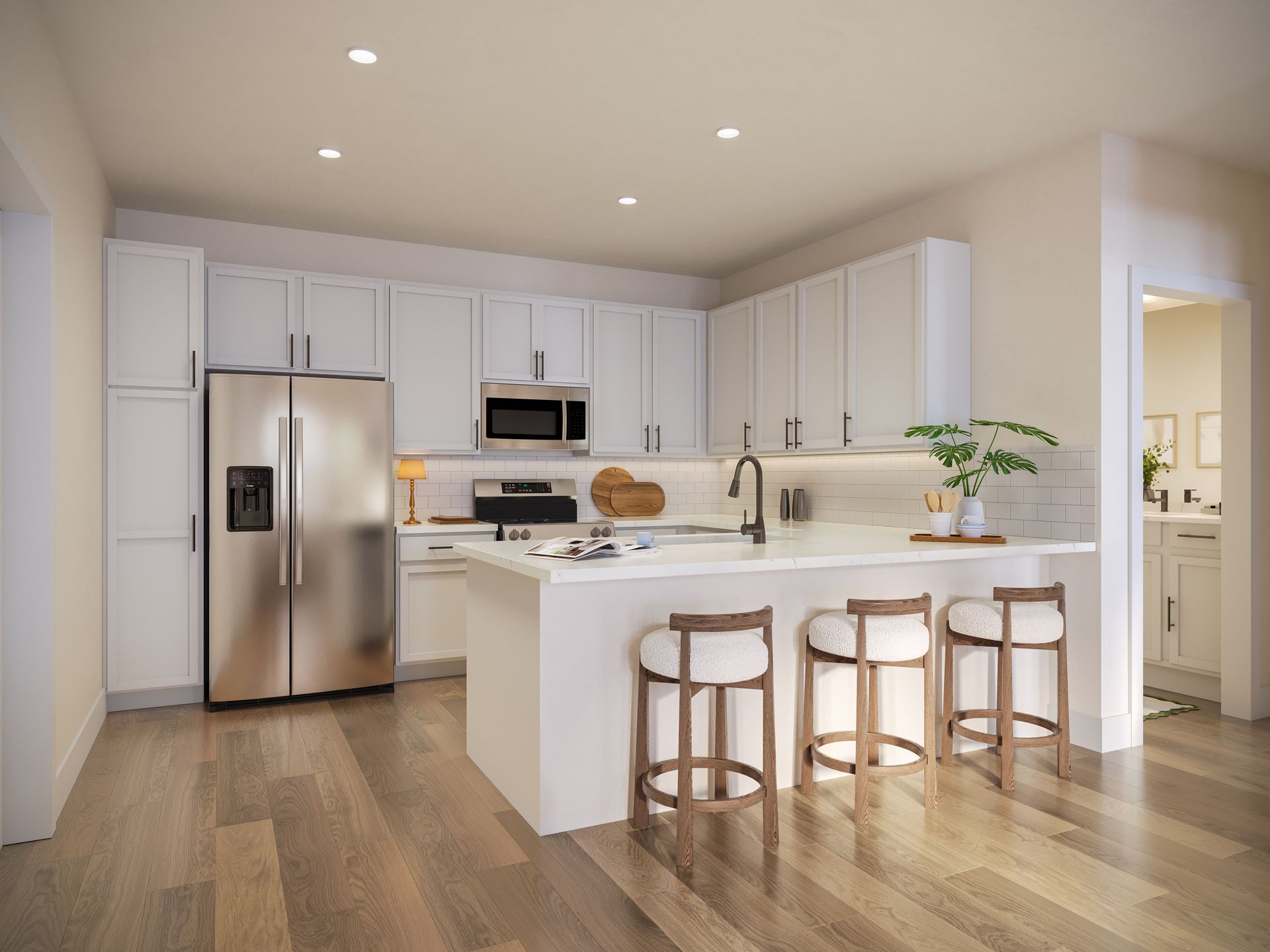 Bright white modern kitchen with island, stainless steel fridge, and three wooden stools on hardwood floor