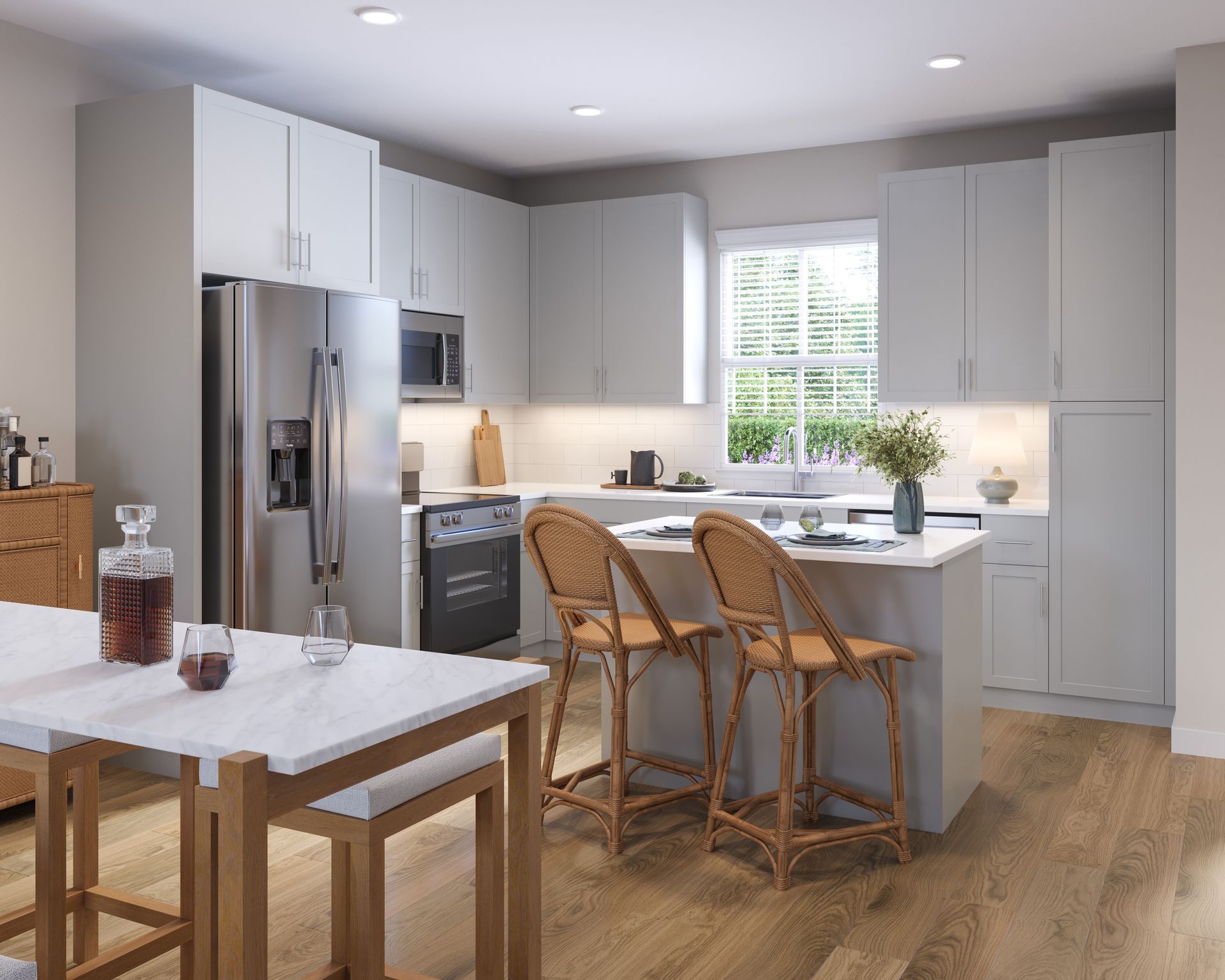 Bright modern kitchen with white cabinets, stainless fridge, island stools, and a wooden dining table