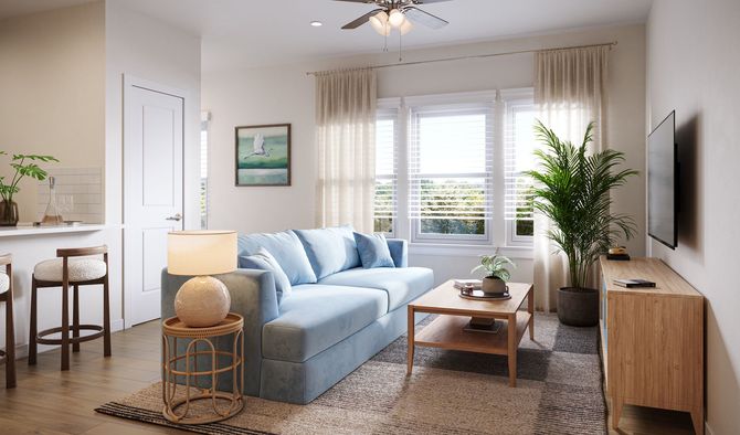Bright living room with a blue sofa, wooden coffee table, potted plant, and wall-mounted TV.