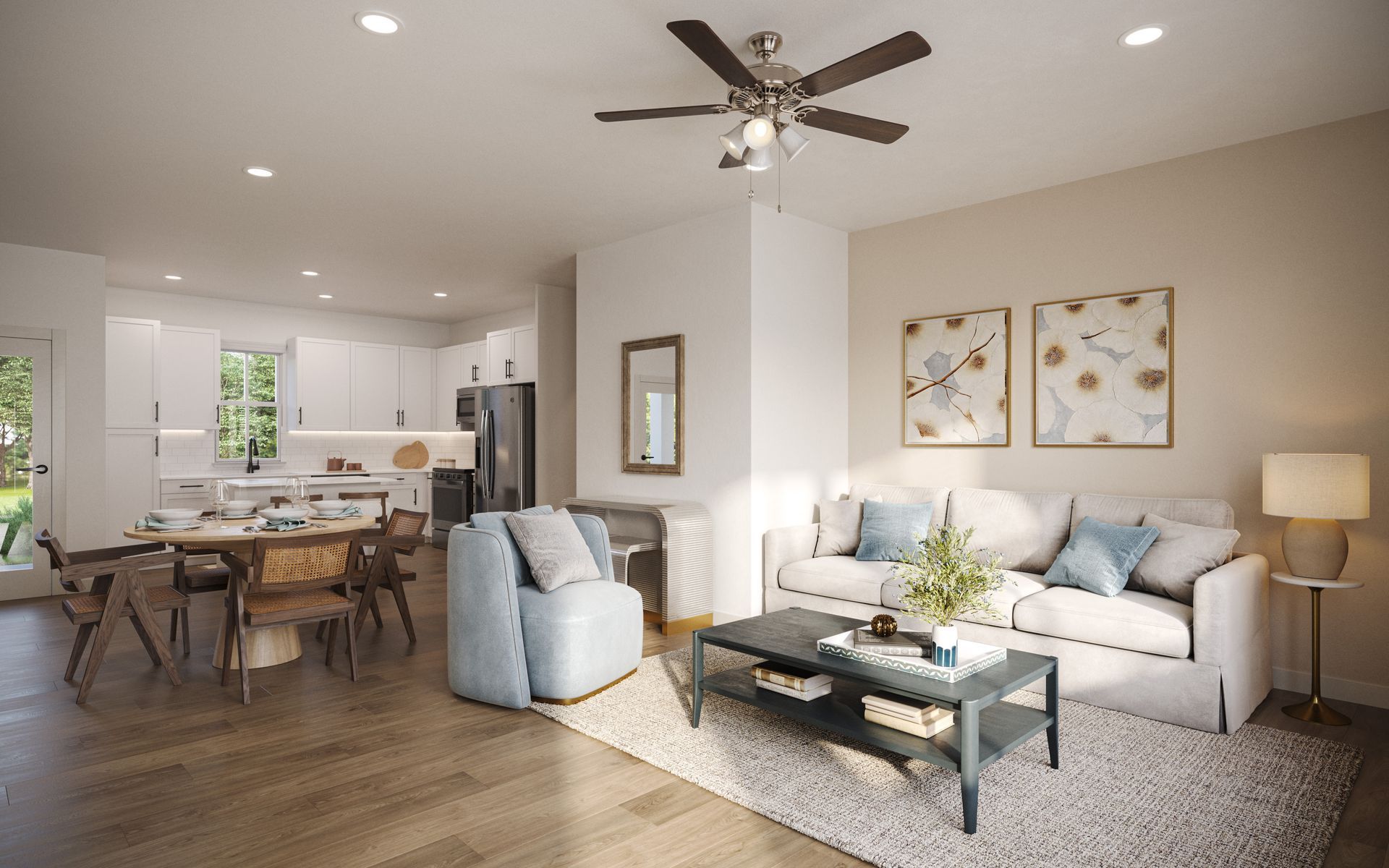 Bright open living room with gray sofas, coffee table, dining area, and white kitchen in the background