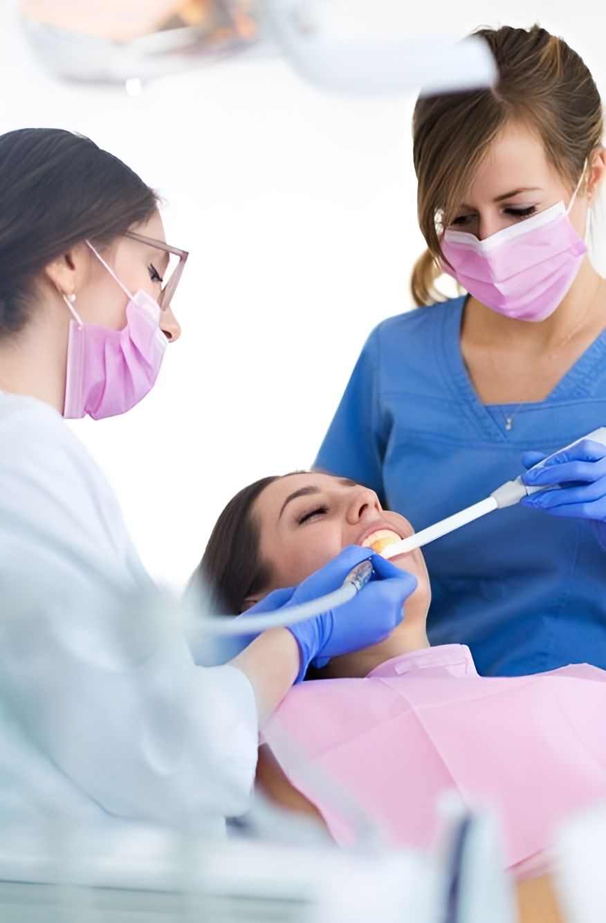 A Woman is Getting Her Teeth Examined by Two Female Dentists — Bytes of Byron–Bio Holistic Dentistry in Lennox Head, NSW