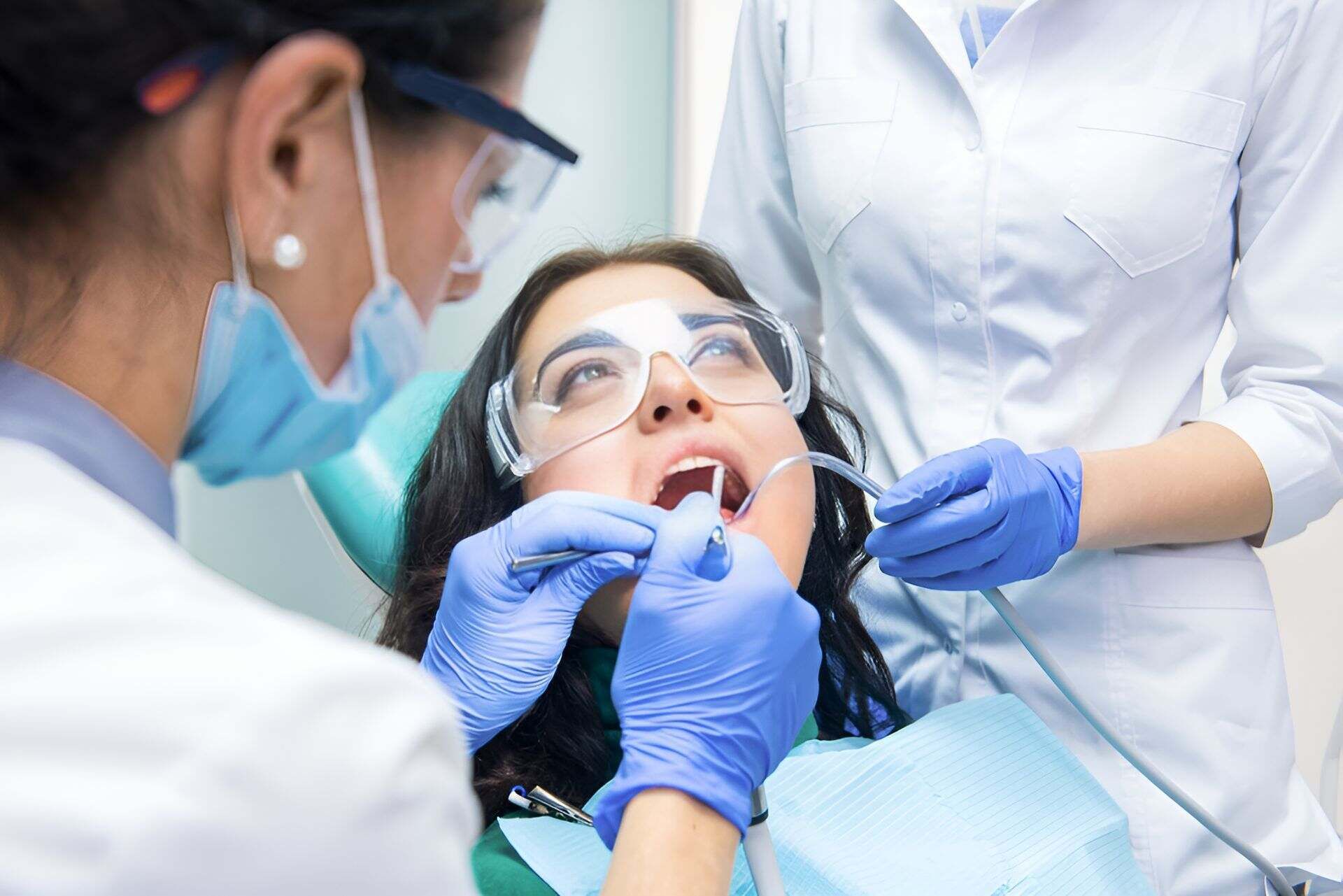 A Woman is Sitting in a Dental Chair Getting Her Teeth Examined — Bytes of Byron–Bio Holistic Dentistry in Byron Bay, NSW