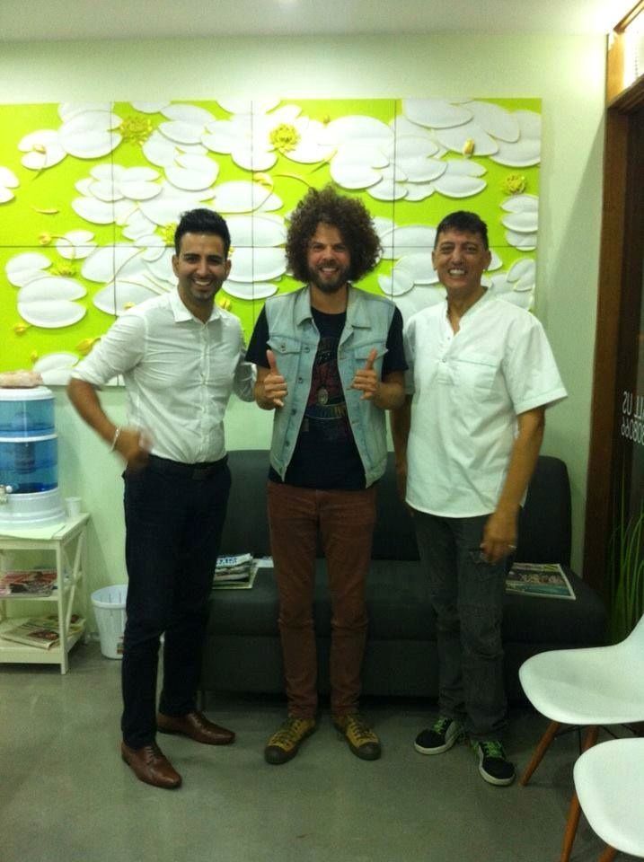 Three Men Are Posing for a Picture in a Waiting Room — Bytes of Byron–Bio Holistic Dentistry in Byron Bay, NSW