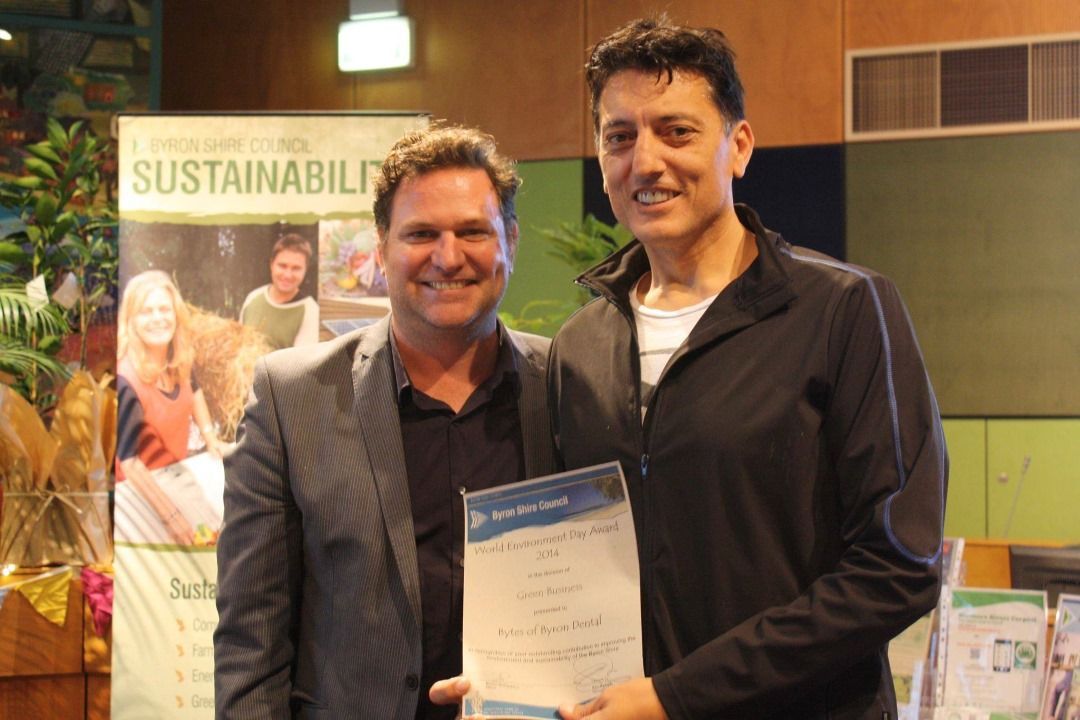 Two Men Are Standing Next to Each Other Holding a Certificate — Bytes of Byron–Bio Holistic Dentistry in Byron Bay, NSW