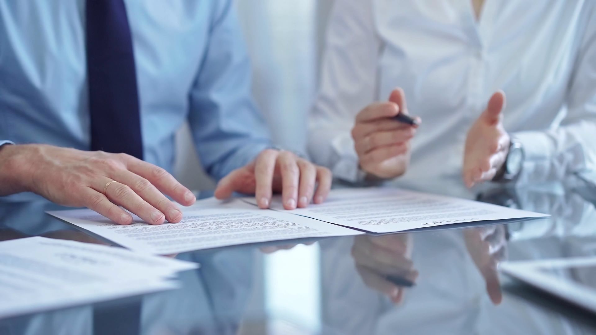 A man and a woman are sitting at a table looking at papers.