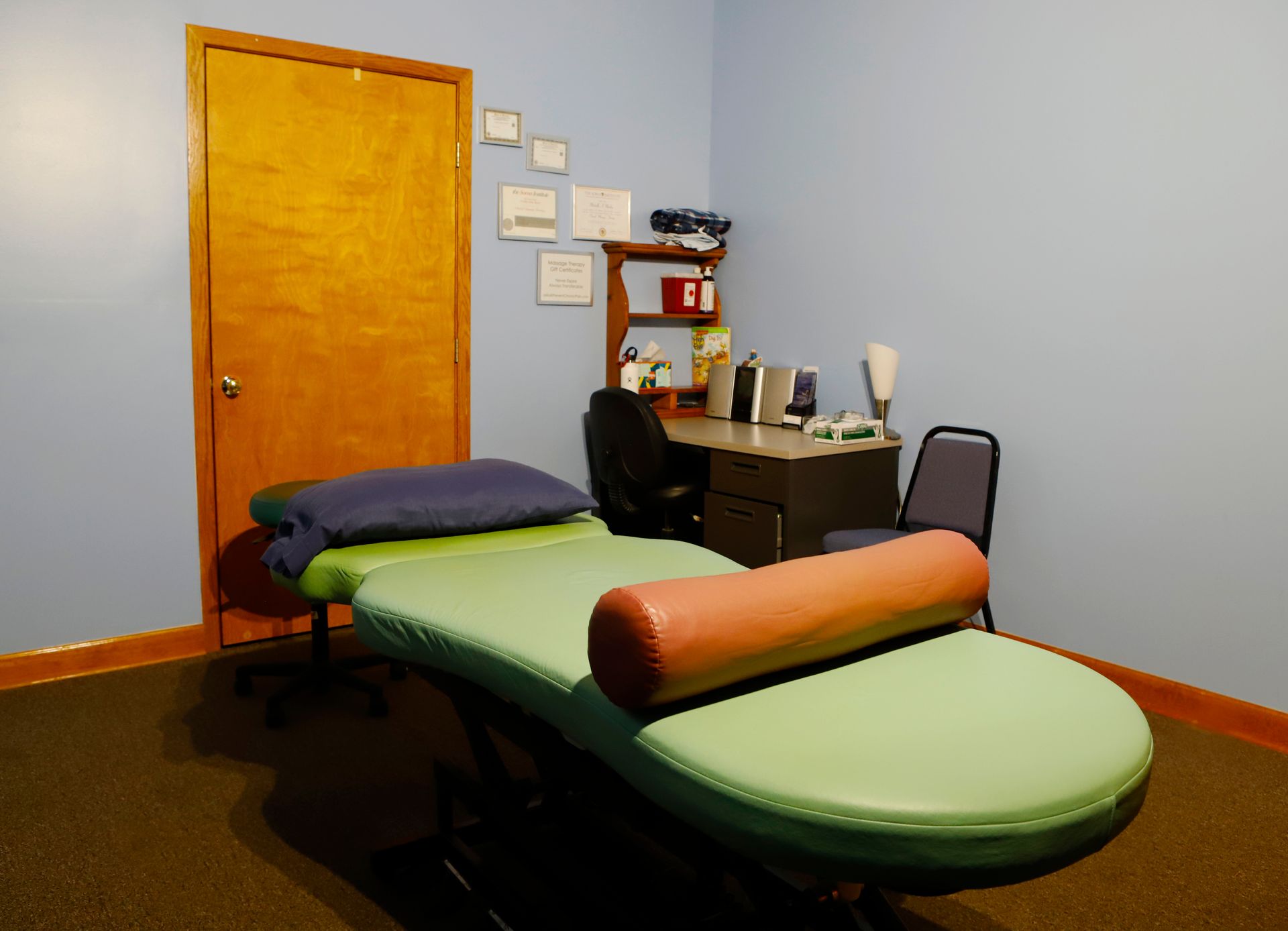 A room with a massage table and a desk