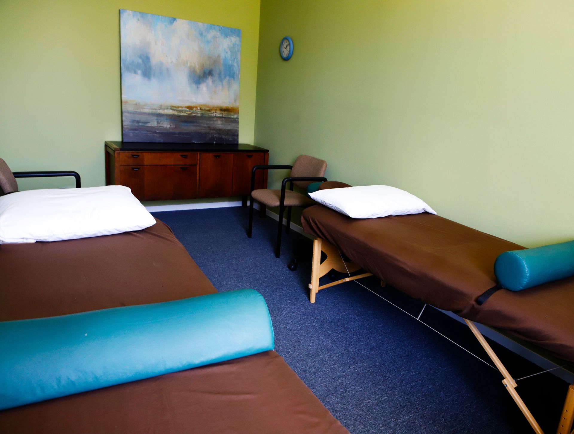 A room with two beds and a painting on the wall