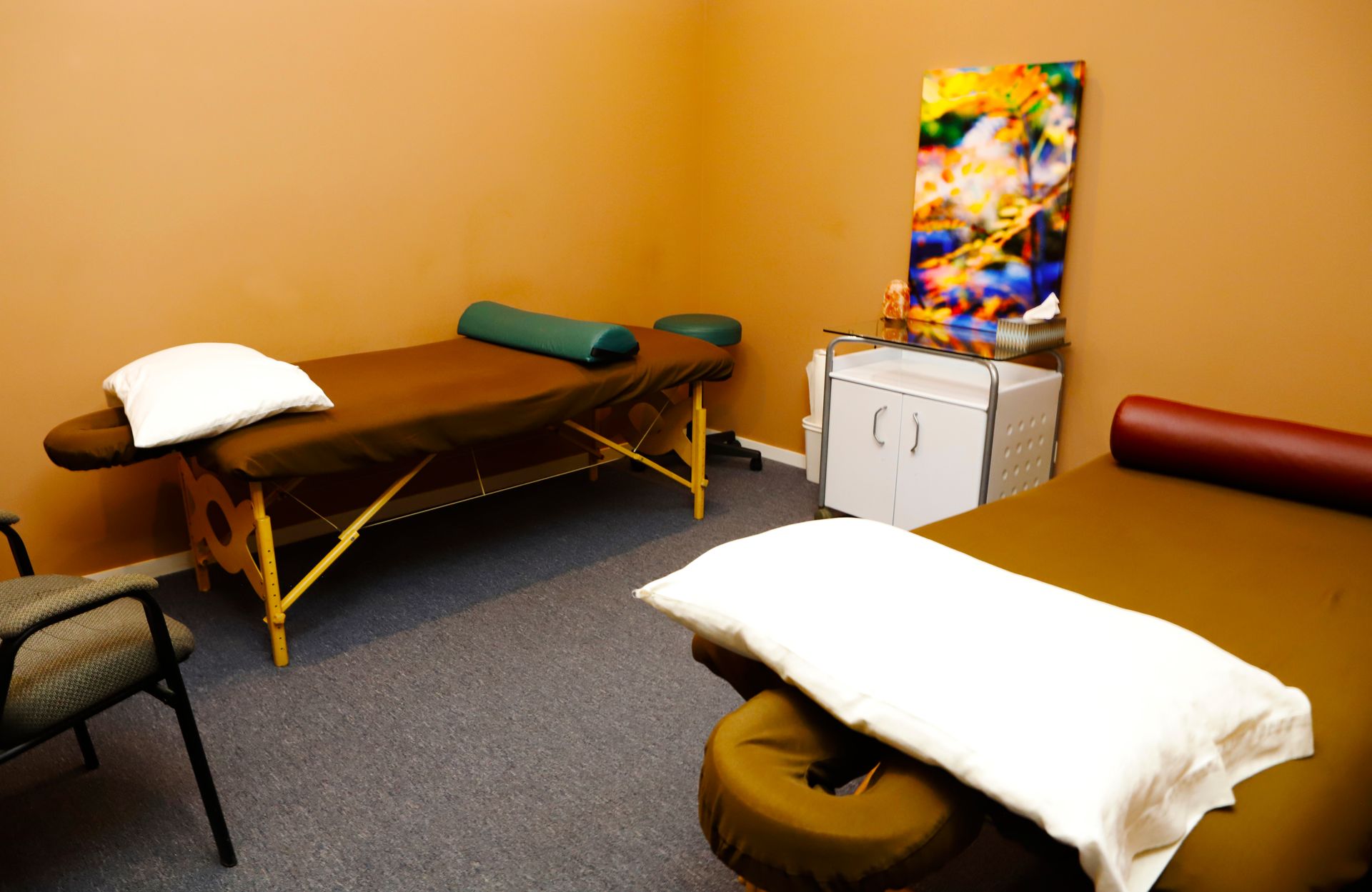 A room with two massage tables and a chair