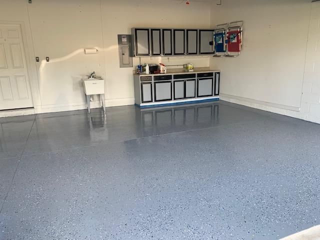 A garage with a sink and cabinets in it.
