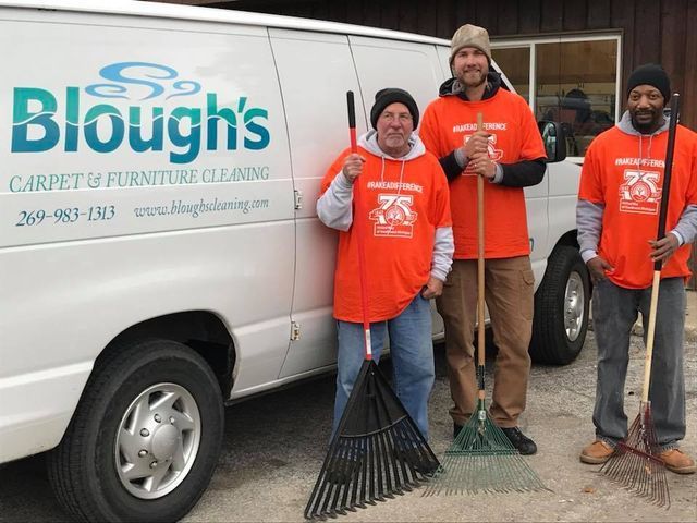 Professional carpet cleaners from Blough's Carpet Cleaning and Restoration standing next to their service van.