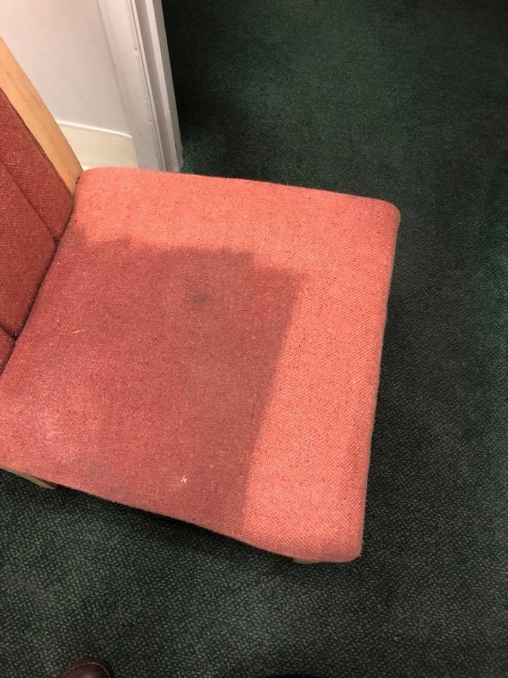Spring carpet cleaning for a dark carpet beside an orange chair in Southwest Michigan
