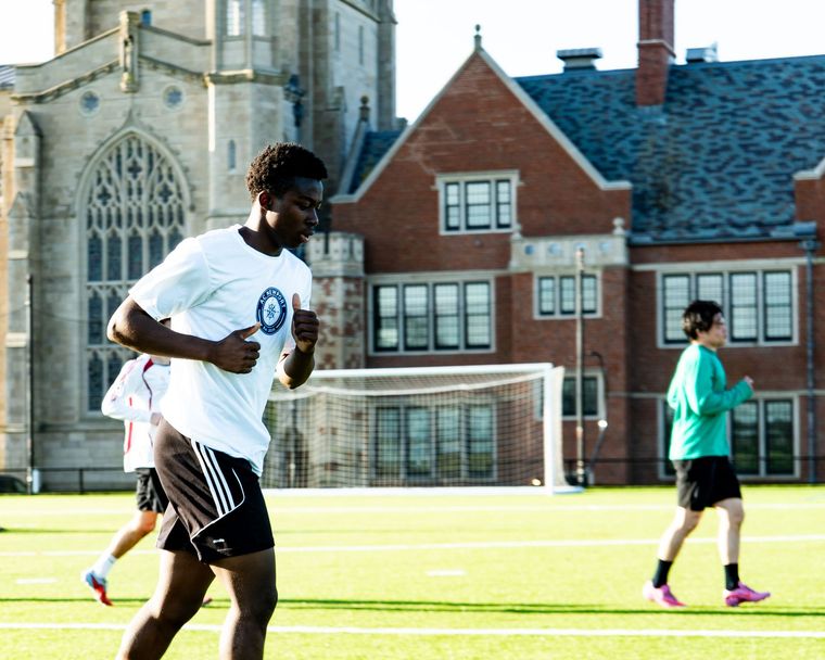 A black and white soccer ball sits on a green grass field.