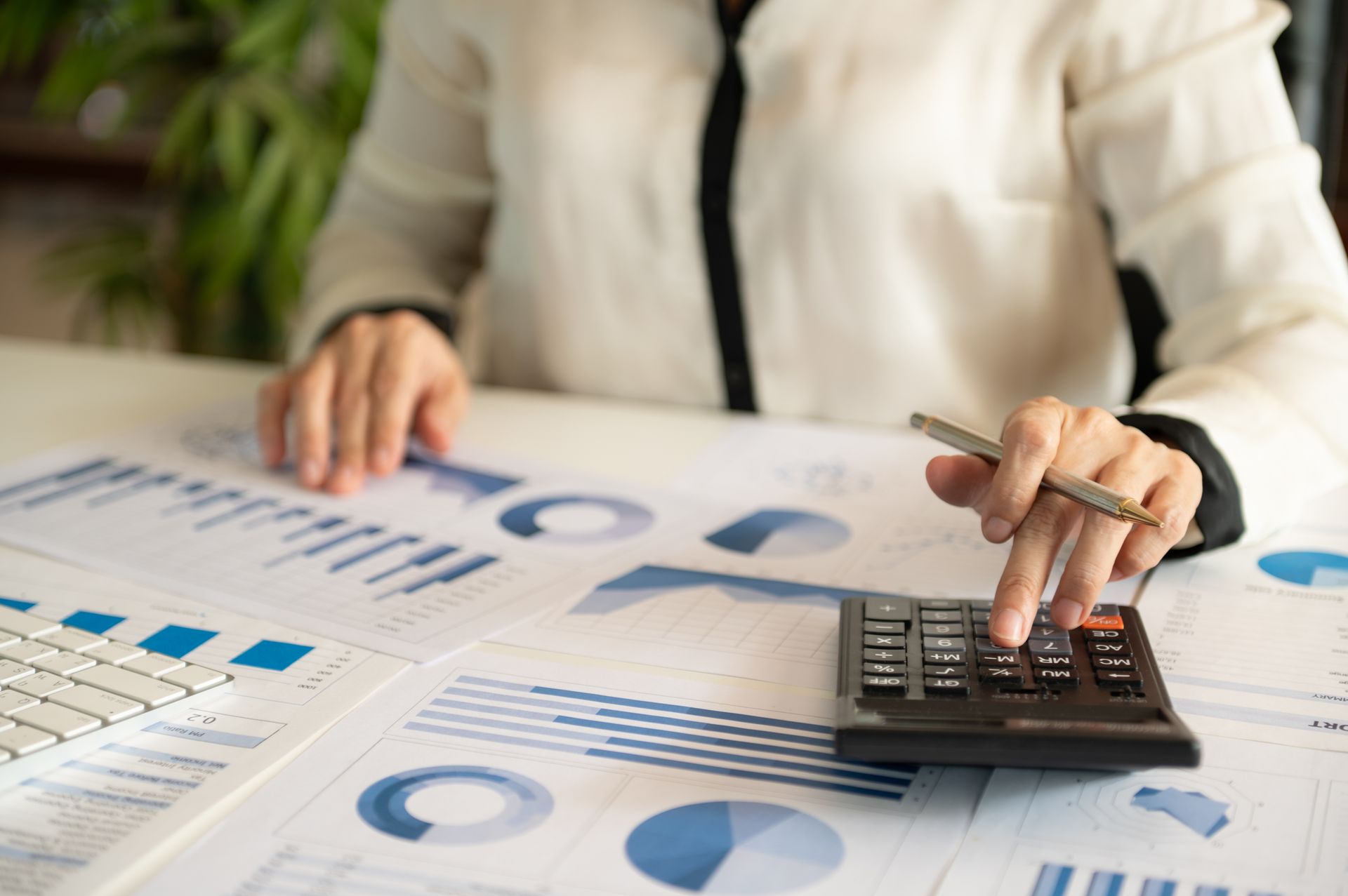 A Person Is Using A Calculator While Holding A Piece Of Paper — Simple Solutions Accounting In Bundaberg West, QLD