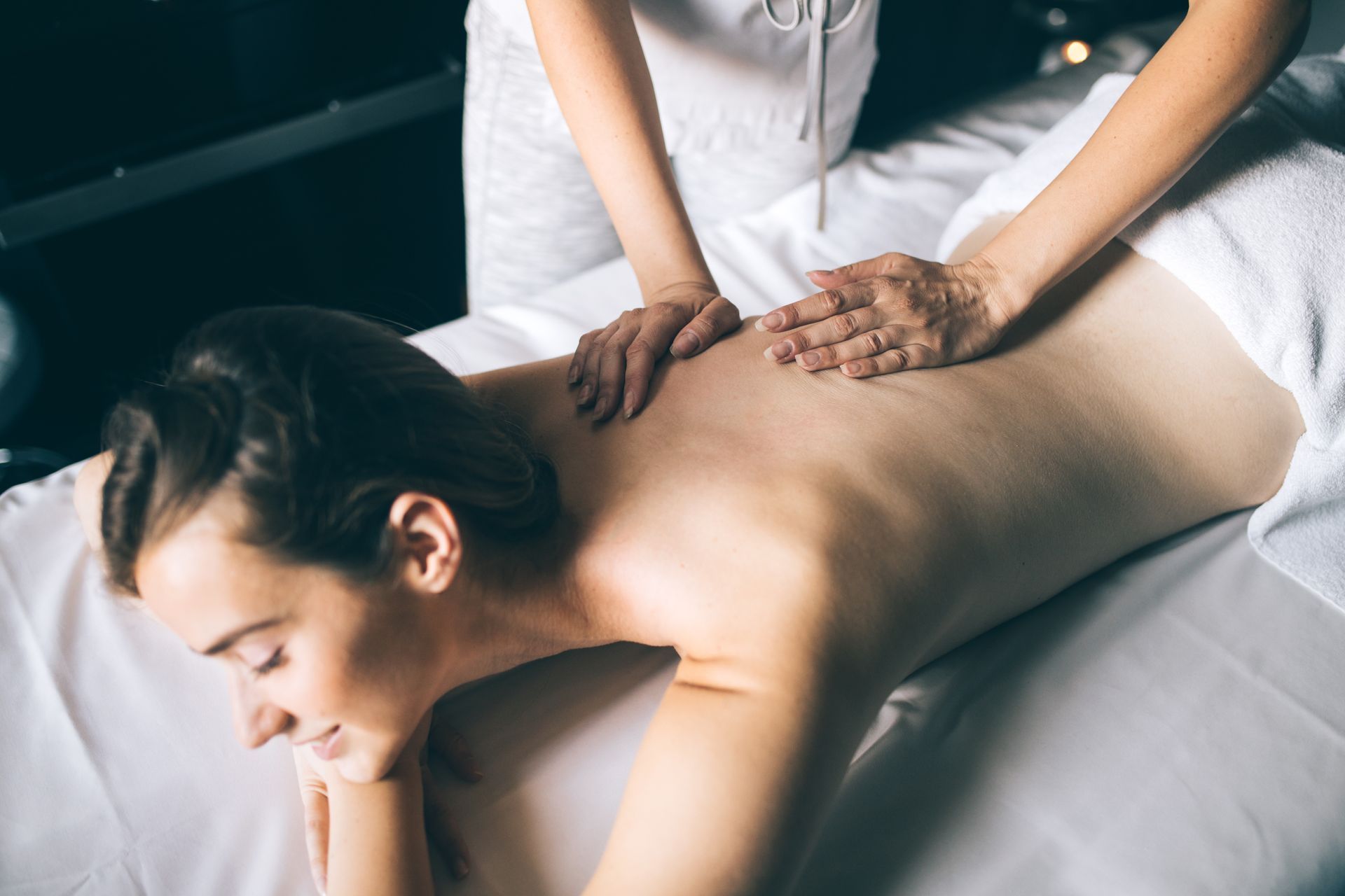 A woman is laying on a massage table getting a massage.
