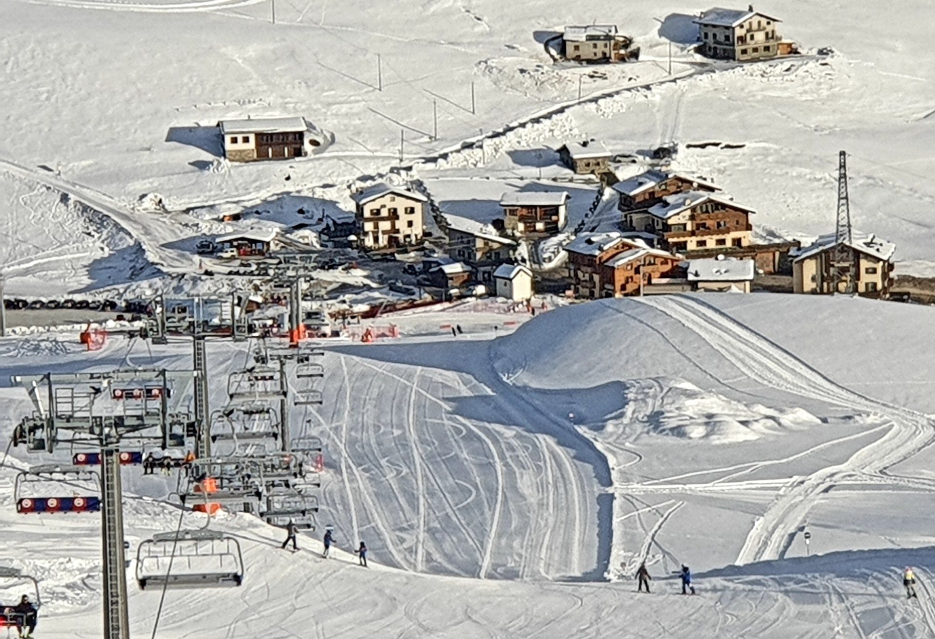 Interno del ristorante con travi in legno, tende rosse, tovaglia a quadri e foto incorniciate.
