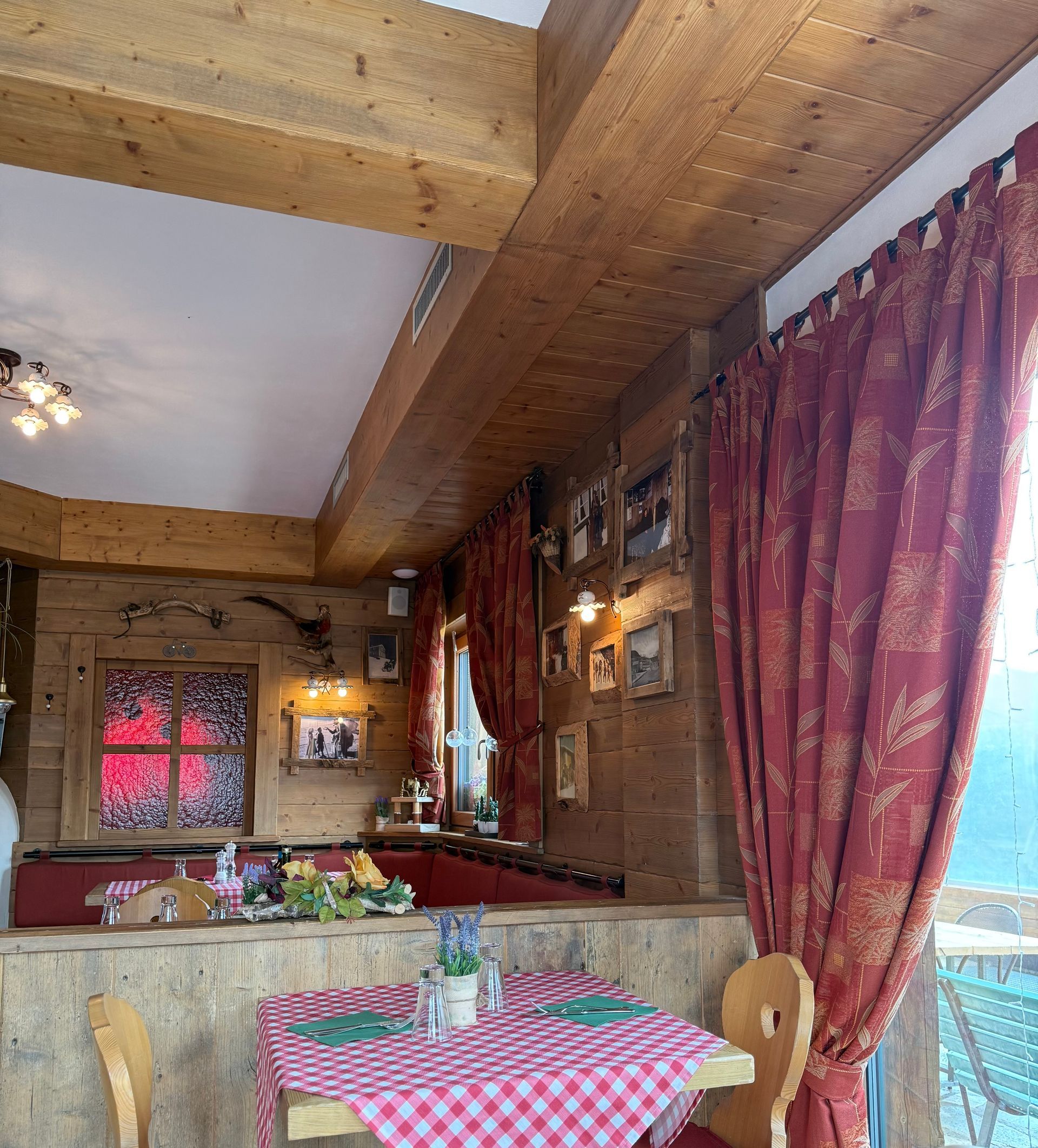 A restaurant with tables and chairs and red curtains