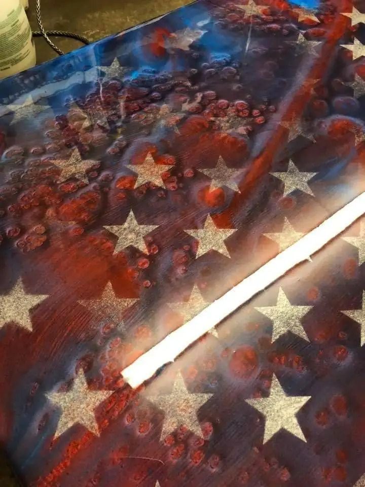 American flag artwork with red and blue abstract background, silver stars, and a white stripe.