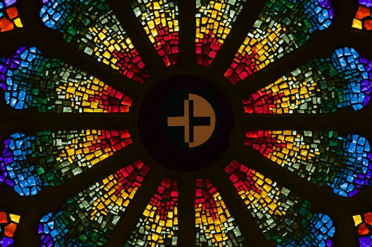 Rose window with a two toned cross in the center.