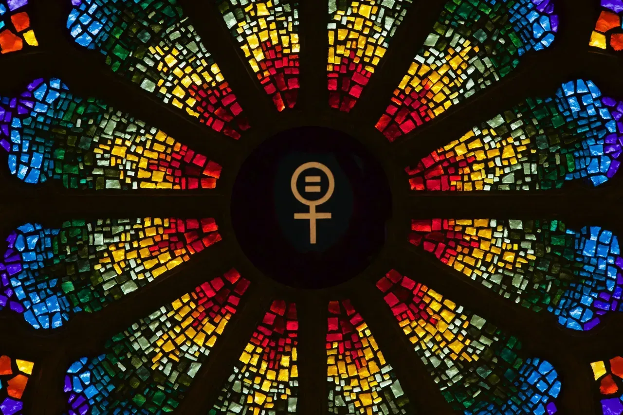Rose Window with the logo for female an equal sign in the center of the female logo.