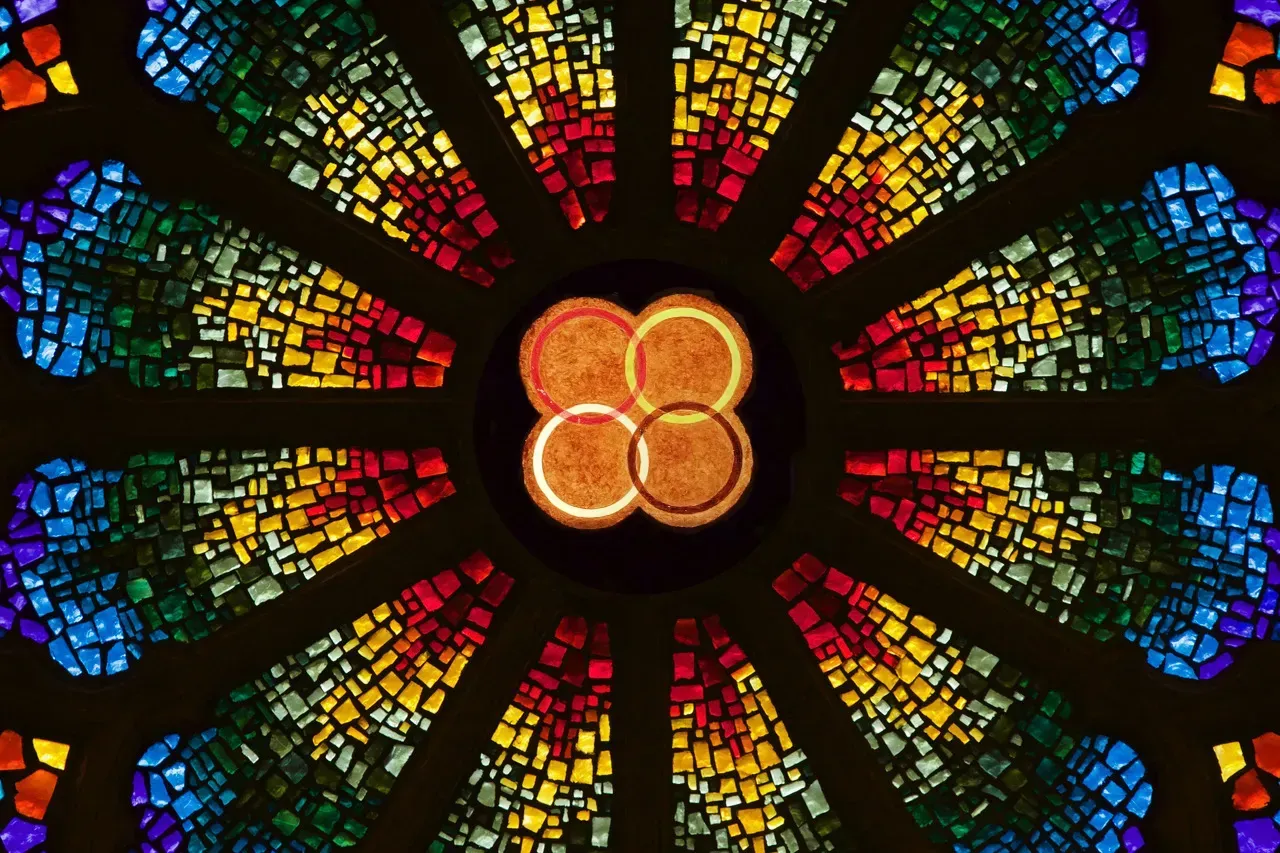 Rose window with 4 rings - red, gold, white and black - in the center.