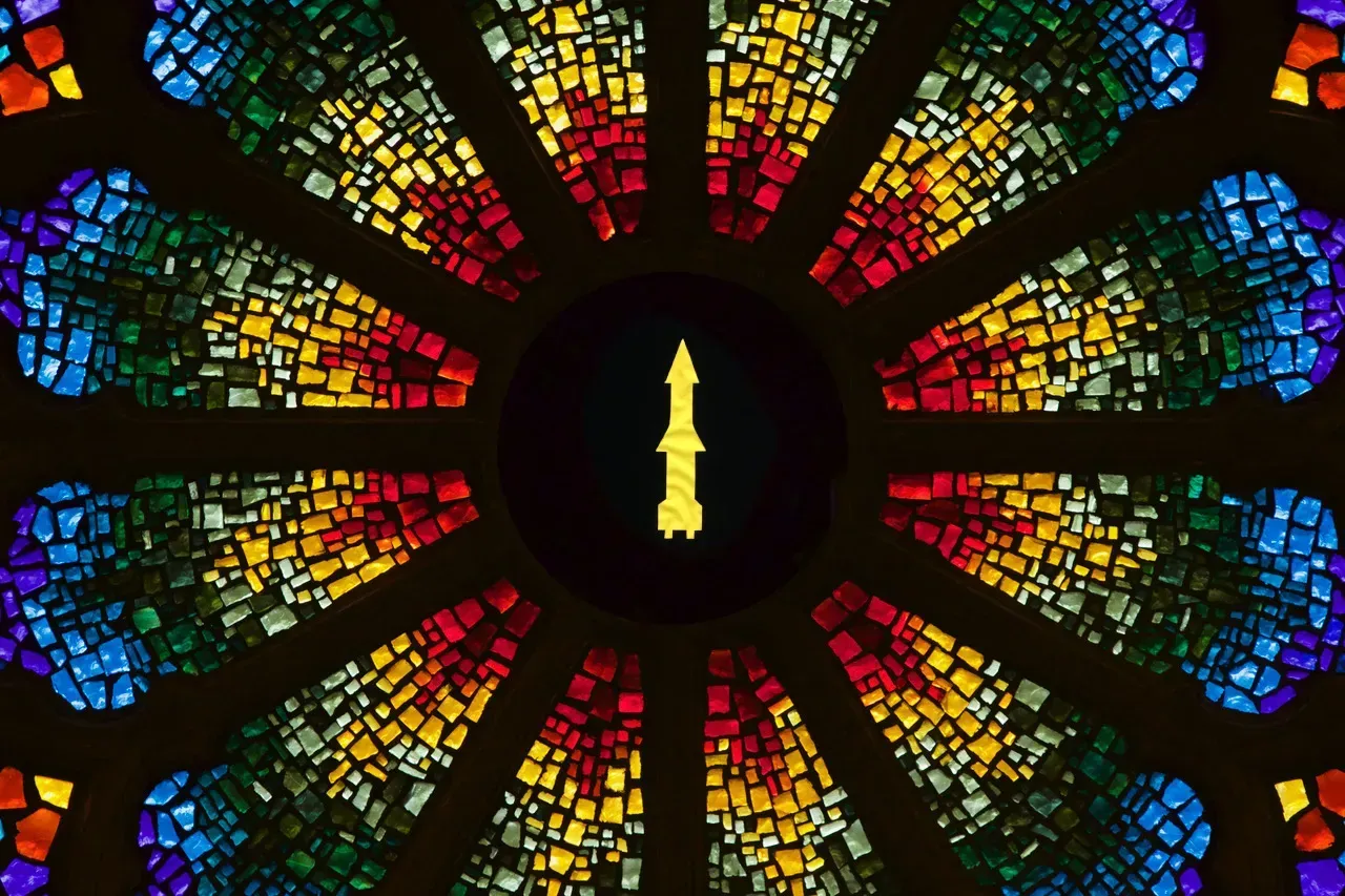 Rose window with a yellow missile in the center.