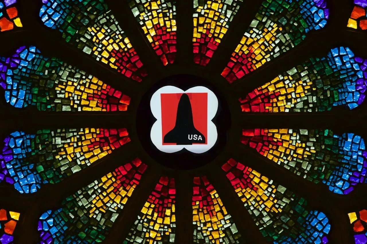 Rose window with a space ship with USA on it in the center.