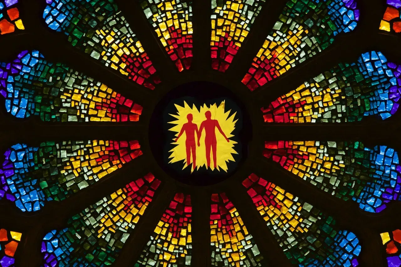 Rose window of two figured walking hand in hand in the center.