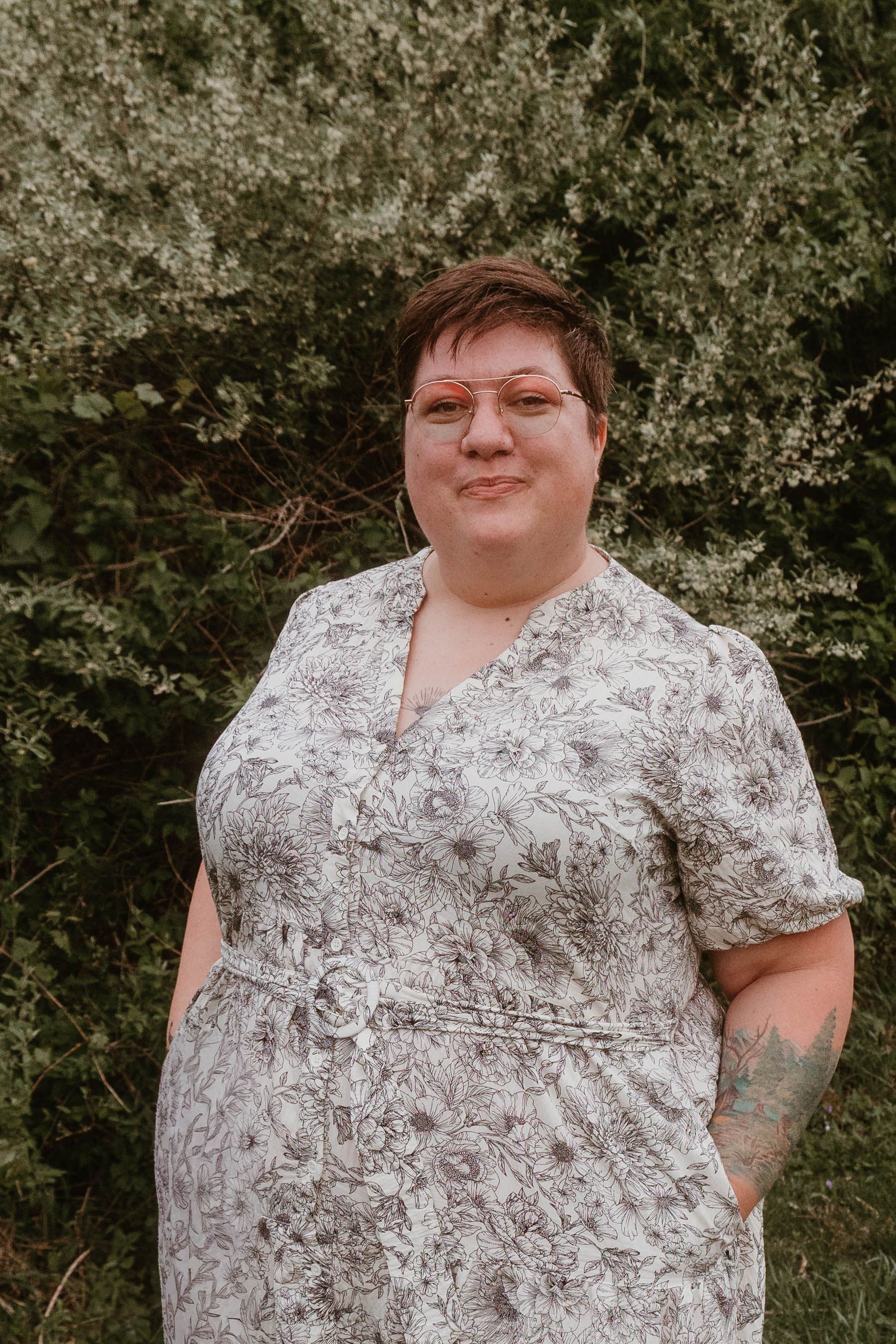 a middle aged white woman with short brown hair wearing white floral overalls