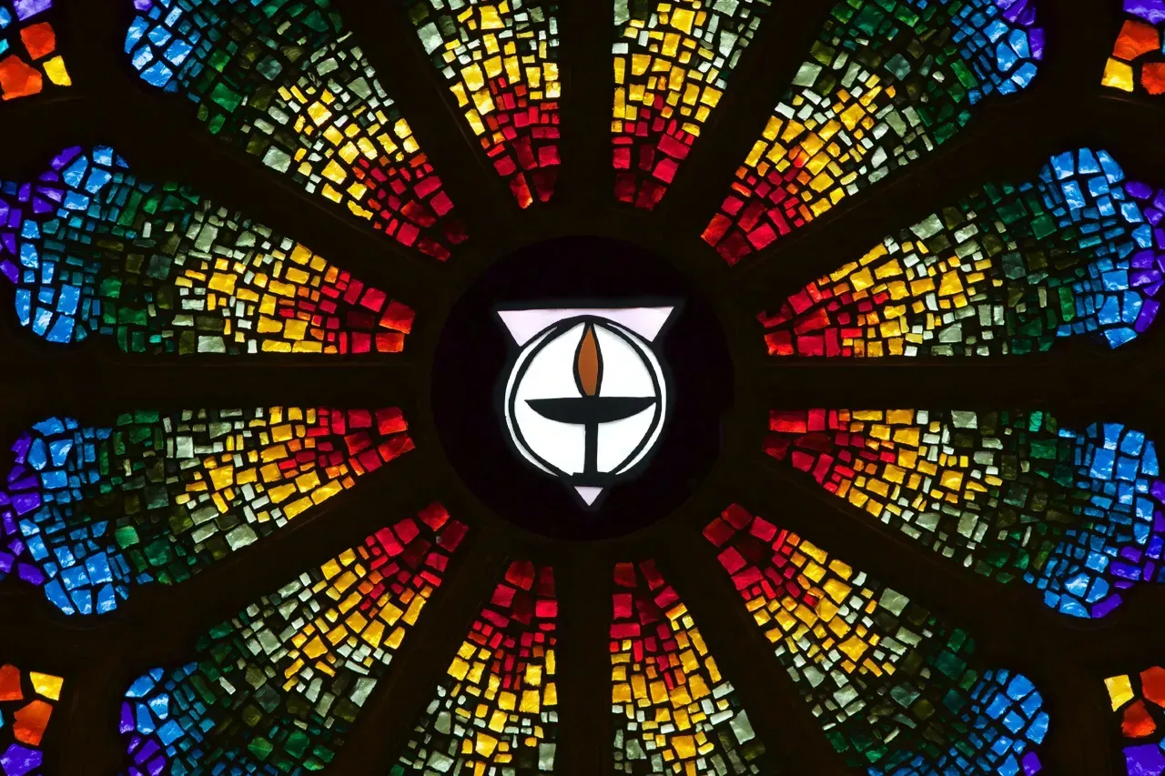 Rose window with a stylized chalice in a circle in the middle.