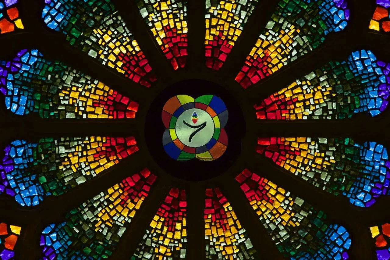 Rose window with a stylized chalice in the center.