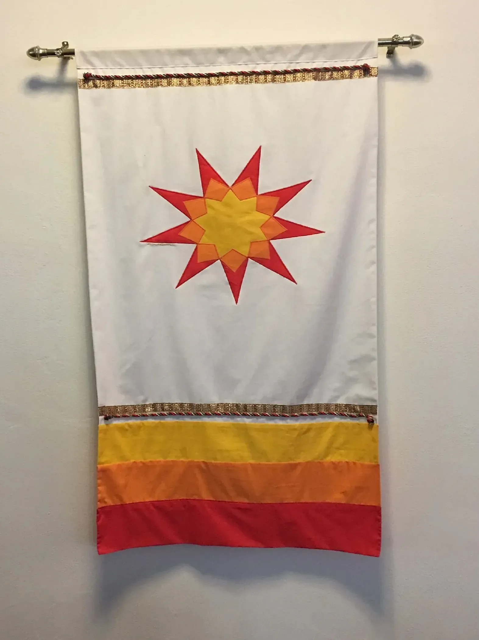 A white banner with a red star in the center to show the Bahai symbol