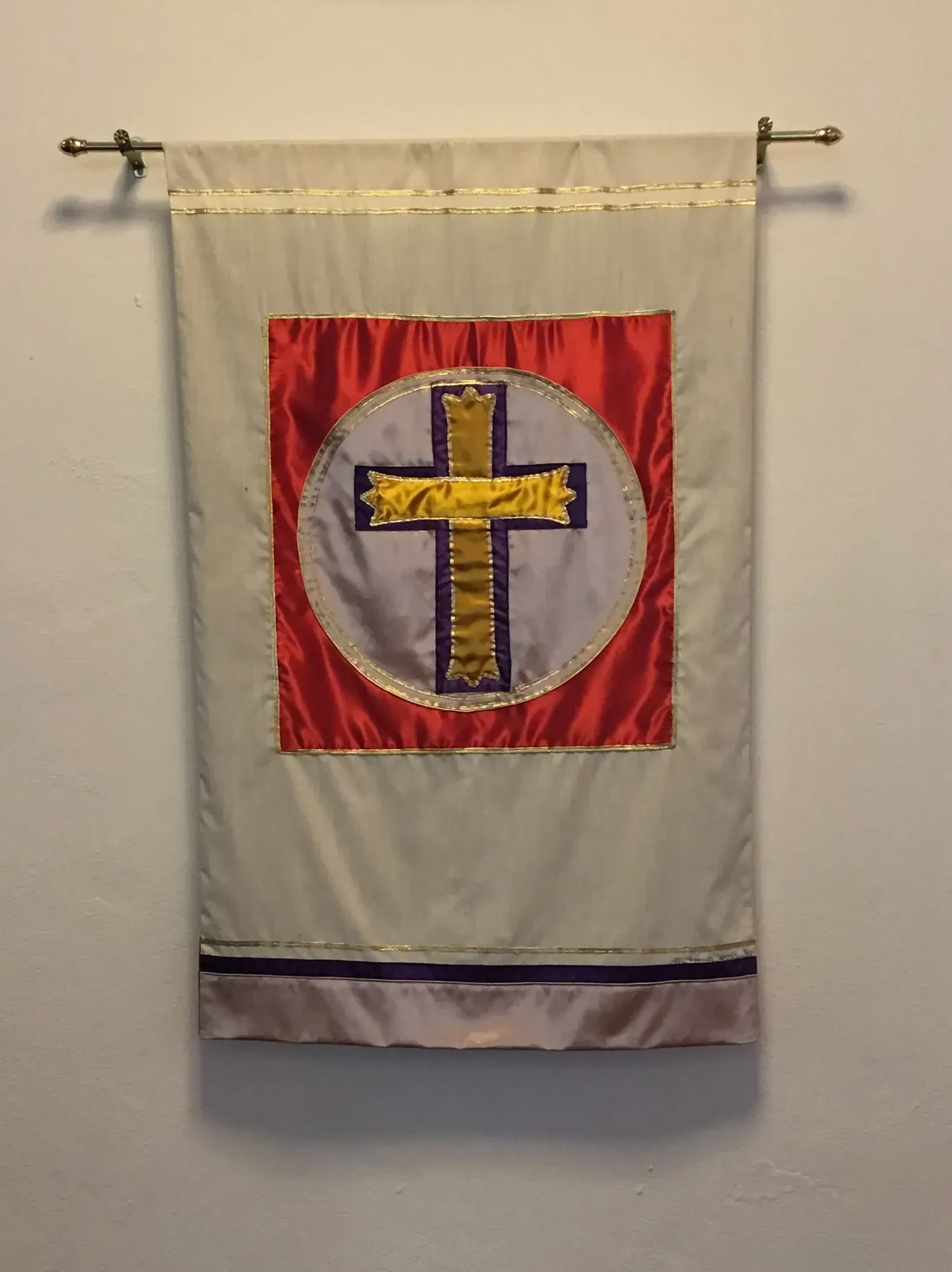 White banner with a red inner banner with a gold cross