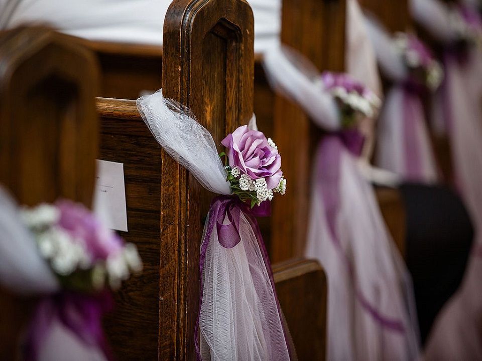 Brown pew edges with a pink and white rose wrapped in white and pink tule