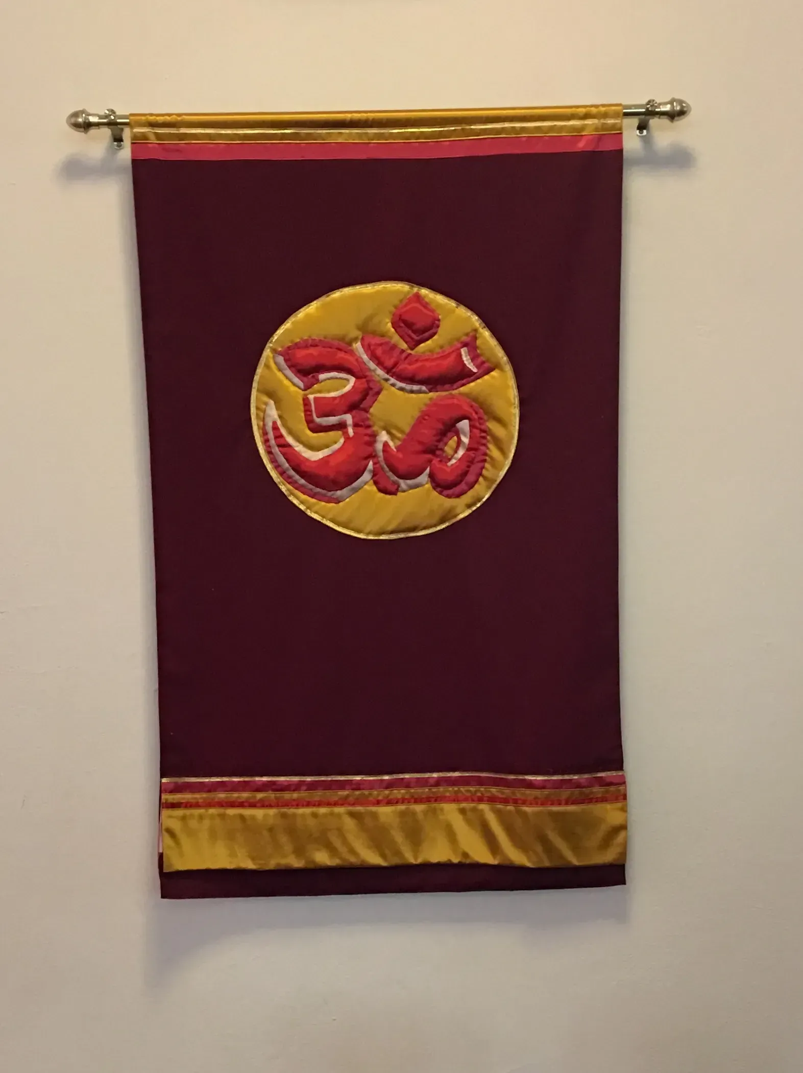 Maroon banner with a yellow circle with red words to represent Hinduism