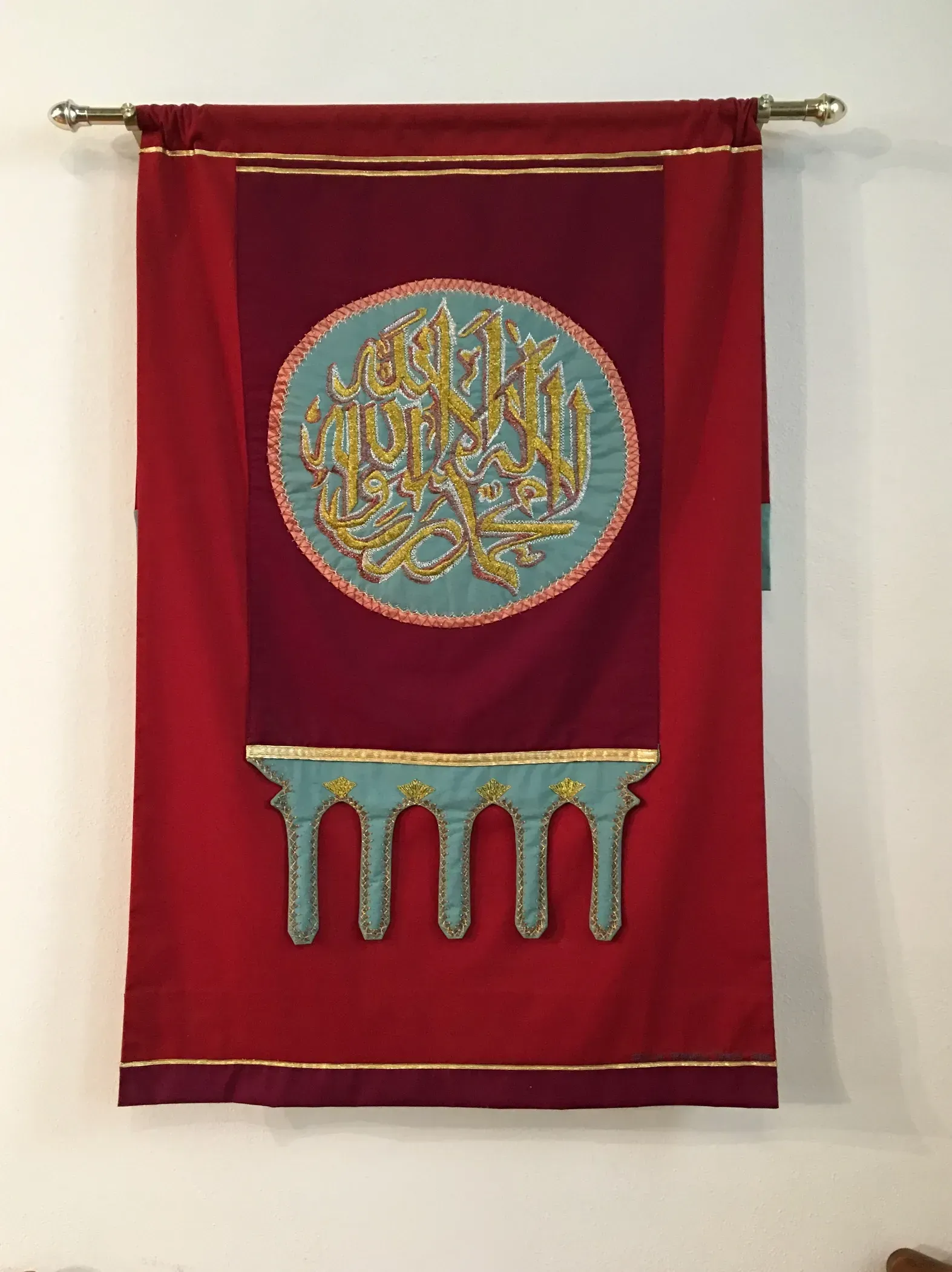 Red banner with a gold Islam design in the middle