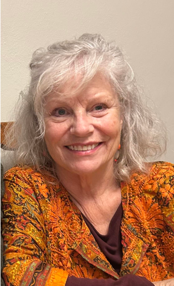 White middle aged woman with gray blonde hair with dark framed glasses