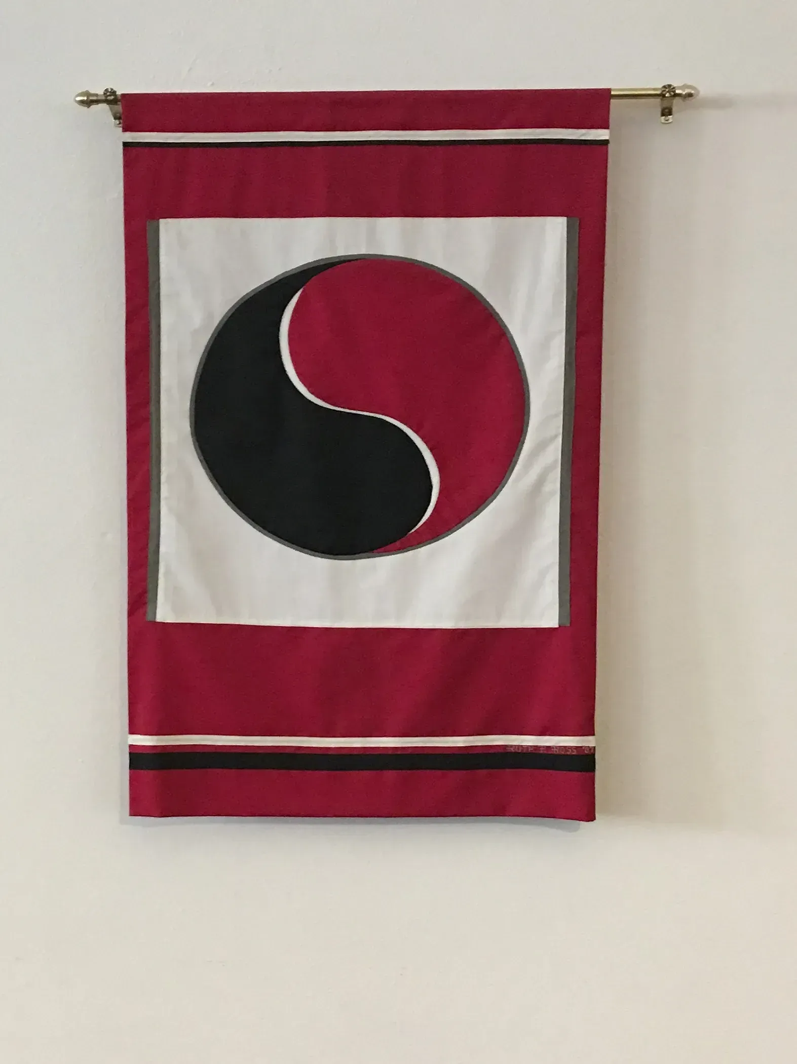 Red banner with black and red ying yang with a white square.