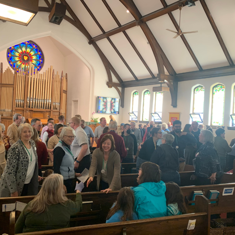 The busy sanctuary during service. The Rose window sits prominently overhead. 