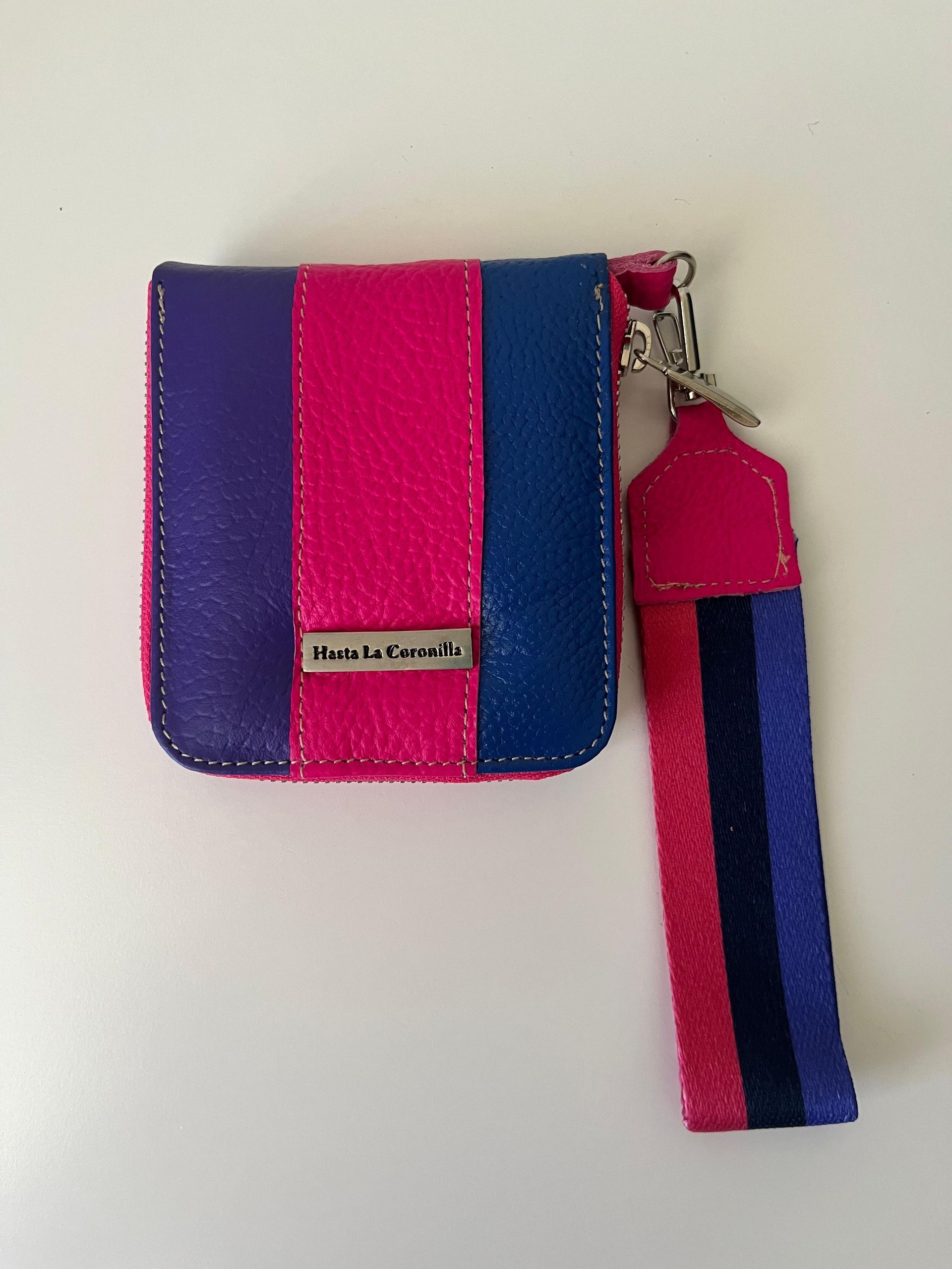 Una billetera pequeña con rayas verticales de color morado, rosa