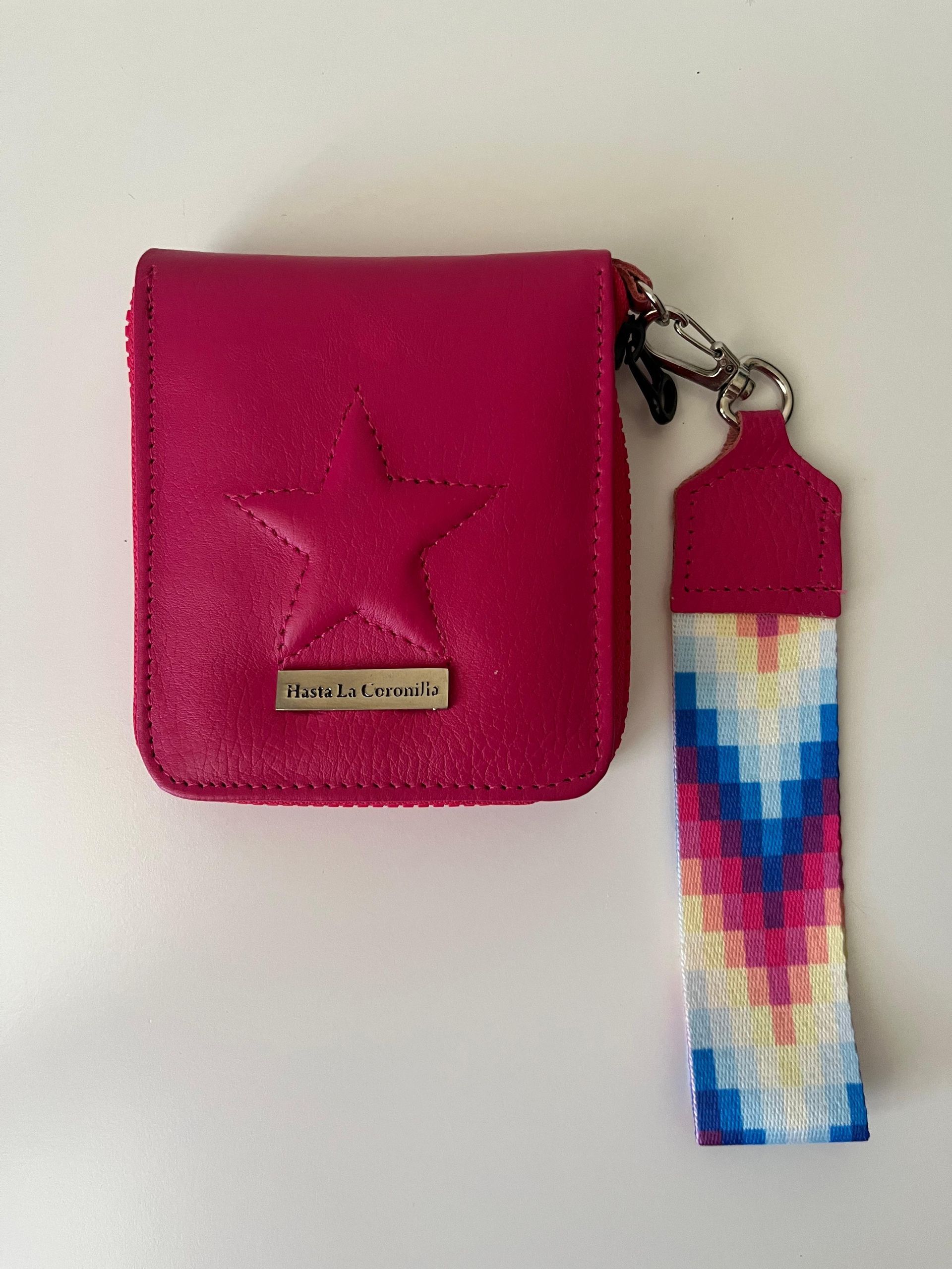 Una billetera de color rosa brillante con una estrella en relieve,