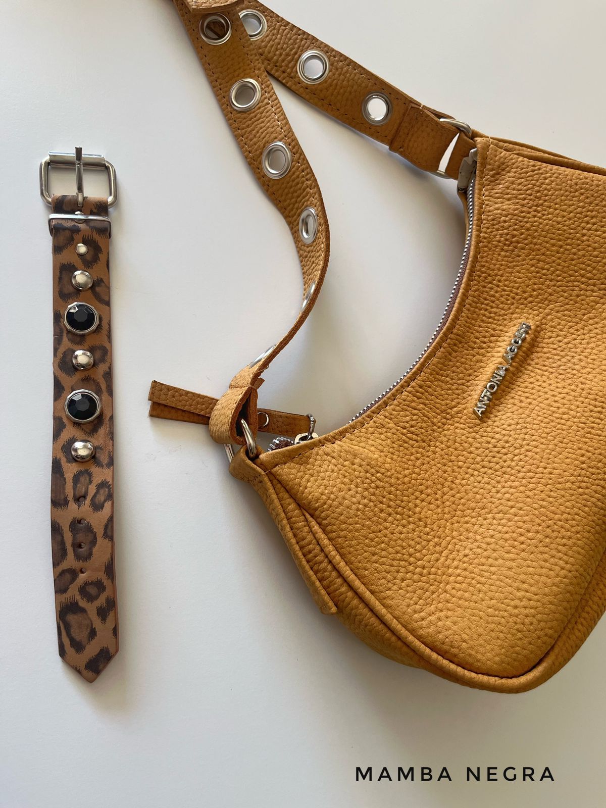 Un bolso de mano con textura de color amarillo dorado con una correa de